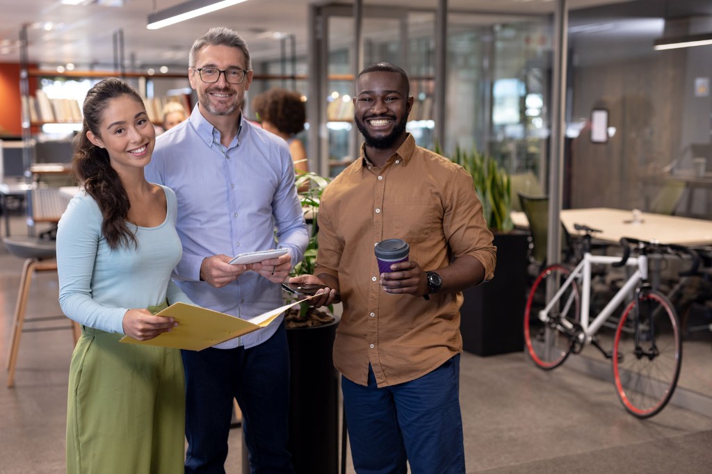 Équipe de professionnels souriants en open space moderne : collaboration et expertise pour vos projets logiciels